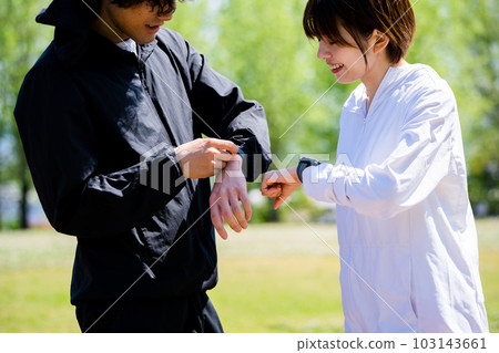 Couple talking while looking at smartwatch Couple talking while looking at smartwatch 103143661