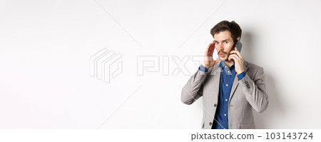 Businessman talking on phone and covering ear, receive call in loud place, cant hear caller, standing on white background Businessman talking on phone and covering ear, receive call in loud place, cant hear caller, standing on white background 103143724