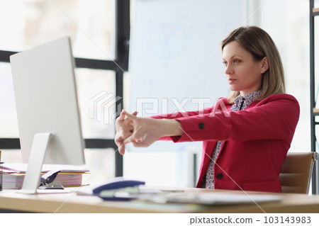 Lady manager stretches arms before starting work on computer Lady manager stretches arms before starting work on computer 103143983
