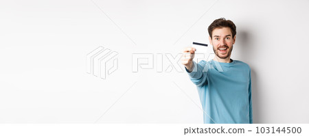 Happy man showing plastic credit card and smiling, recommending bank, standing over white background Happy man showing plastic credit card and smiling, recommending bank, standing over white background 103144500
