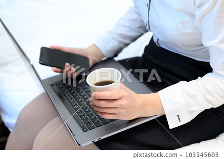 坐在床上喝咖啡並使用智能手機和電腦的女人 坐在床上喝咖啡並使用智能手機和電腦的女人 103145603