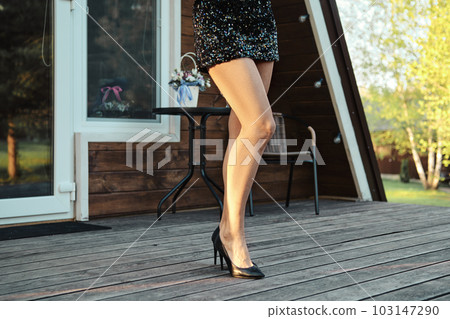 Female legs in glitter dress on terrace 103147290