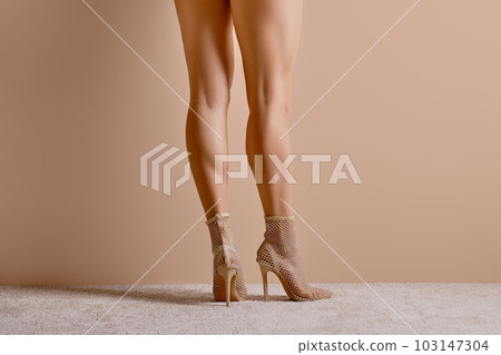 Back side view of female legs in high heel ankle boots with glitter 103147304