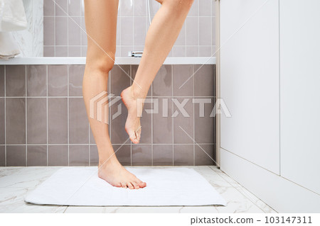 Unrecognizable woman is standing on a towel on the floor after taking bath Unrecognizable woman is standing on a towel on the floor after taking bath 103147311