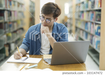 Student studying at library. 103147472