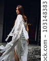 a young girl in a white dress dancing, sewn with her own hands, slow movement and singing outdoors in a religious park, street, having fun alone, emotionally 103148383