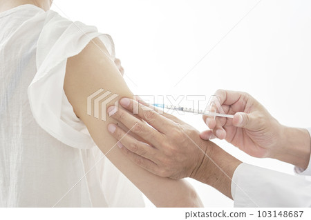 Middle-aged woman getting an injection in her arm faceless Middle-aged woman getting an injection in her arm faceless 103148687