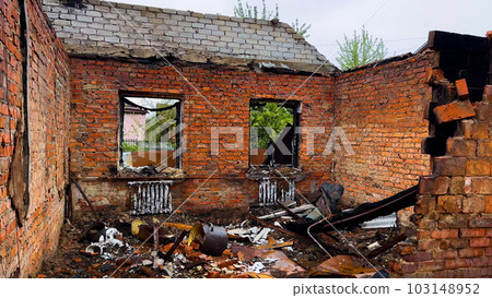 A destroyed residential building in a Ukrainian village. A house without walls and a roof. War A destroyed residential building in a Ukrainian village. A house without walls and a roof. War 103148952