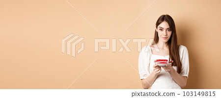Beautiful birthday girl holding cake with candle, making wish, celebrating b-day on beige background 103149815