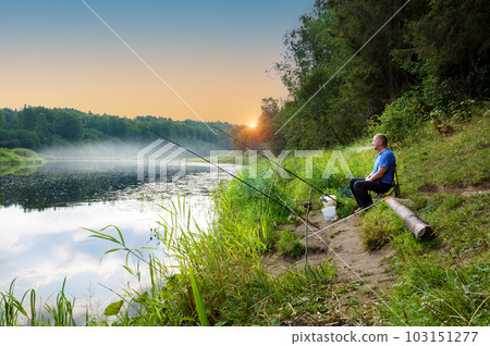 In the early summer morning, a fisherman is fishing in the upper reaches of the Volga River. In the early summer morning, a fisherman is fishing in the upper reaches of the Volga River. 103151277