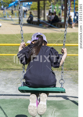 Girl playing on the swing Park playground equipment 103151865