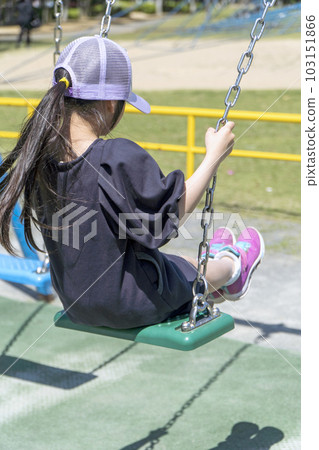 Girl playing on the swing Park playground equipment 103151866