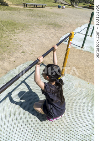 Girl playing with a horizontal bar playground equipment Girl playing with a horizontal bar playground equipment 103151950
