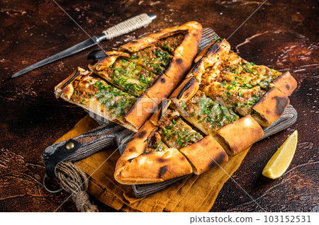 Traditional Turkish baked pide, Middle Eastern snack. Turkish pizza. Dark background. Top view 103152531