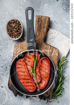 Cooking of Turkish Sucuk beef meat sausage in a skillet. Gray background. Top view Cooking of Turkish Sucuk beef meat sausage in a skillet. Gray background. Top view 103152543