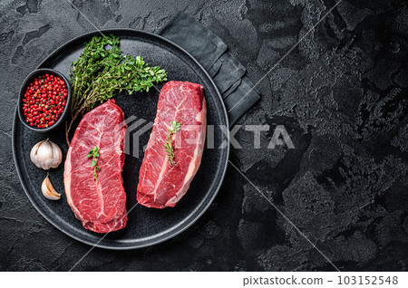 Dry aged Raw top blade flat Iron beef meat steaks. Black background. Top View. Copy space Dry aged Raw top blade flat Iron beef meat steaks. Black background. Top View. Copy space 103152548