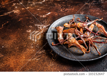 Spicy Dip fried duck tongue. Dark background. Top view. Copy space 103152647
