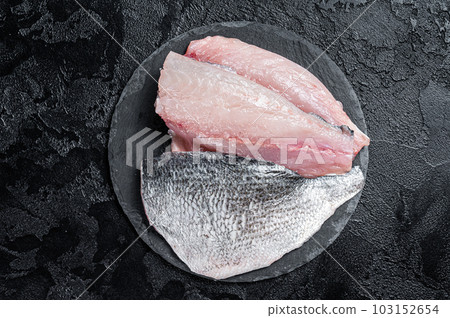 Raw Sea bream Dorado fish fillets. Black background. Top view Raw Sea bream Dorado fish fillets. Black background. Top view 103152654