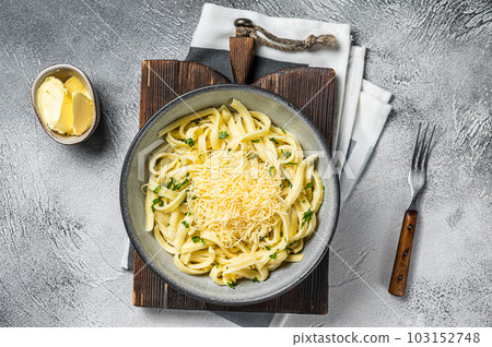 Spaetzle German egg noodles with cheese served with parsley. White background. Top view Spaetzle German egg noodles with cheese served with parsley. White background. Top view 103152748