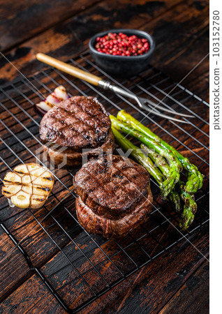 Fillet Mignon grilled Steak with asparagus, beef tenderloin meat. Wooden background. Top view Fillet Mignon grilled Steak with asparagus, beef tenderloin meat. Wooden background. Top view 103152780