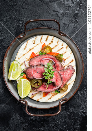 Carne Asada Tacos with grilled steak, green sauce, jalapenos and onion, Mexican food. Black background. top view 103152794