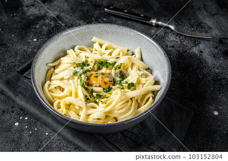 Traditional Bavarian Spaetzle egg Noodles with Butter and Parsley. Black background. Top view Traditional Bavarian Spaetzle egg Noodles with Butter and Parsley. Black background. Top view 103152804