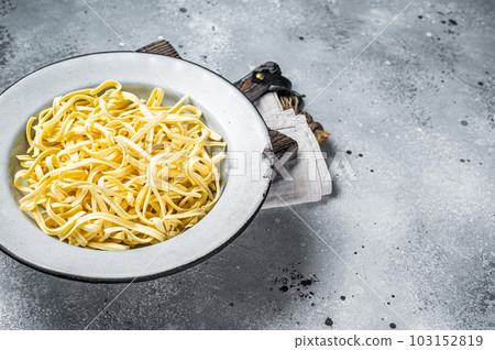 Raw dried spaetzle egg noodle. Gray background. Top view. Copy space 103152819