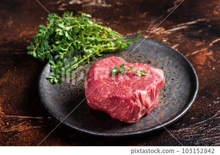 Prime Fillet Mignon Beef steak, Dry aged raw tenderloin meat. Dark background. Top view Prime Fillet Mignon Beef steak, Dry aged raw tenderloin meat. Dark background. Top view 103152842