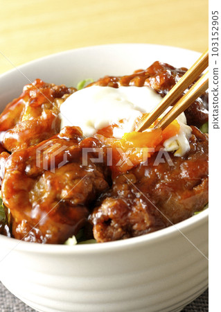 Cracking the eggs in the fried chicken rice bowl with ontama topping Cracking the eggs in the fried chicken rice bowl with ontama topping 103152905