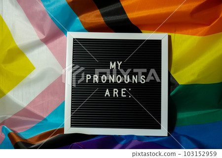 MY PRONOUNS ARE text Neo pronouns concept on Rainbow flag background gender pronouns. Non-binary people rights transgenders. Lgbtq community support assume my gender tolerance equal rights MY PRONOUNS ARE text Neo pronouns concept on Rainbow flag background gender pronouns. Non-binary people rights transgenders. Lgbtq community support assume my gender tolerance equal rights 103152959