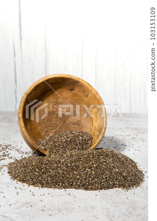 Chia seeds fall from wooden bowl. Healthy superfood rich in Omega 3 fatty acids. Dry healthy natural ingredient. Chia grains are falling Chia seeds fall from wooden bowl. Healthy superfood rich in Omega 3 fatty acids. Dry healthy natural ingredient. Chia grains are falling 103153109