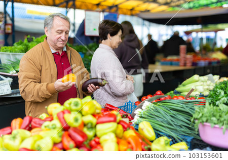 Aged man and woman customers buying pepper in open-air market Aged man and woman customers buying pepper in open-air market 103153601