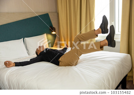 Young man in hotel room feeling enjoyed and excited 103155482