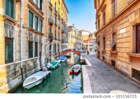 cityscape of Venice with narrow canals, boats and gondolas and bridges with traditional buildings 103156723