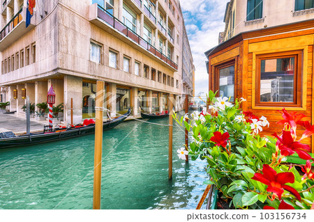 cityscape of Venice with narrow canals, boats and gondolas and bridges with traditional buildings 103156734