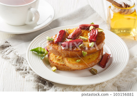 Toasted hot french toast with baked rhubarb, pistachios, honey close-up. Horizontal 103156881