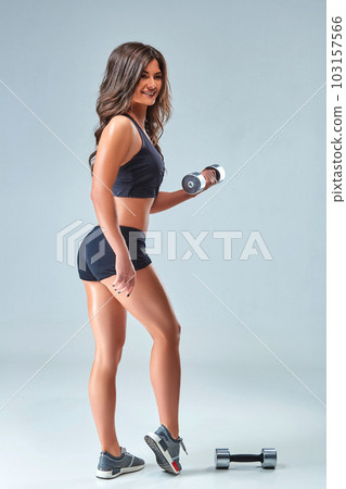 Athletic Woman Pumping Up Muscles With Dumbbells. Photo Of Sporty