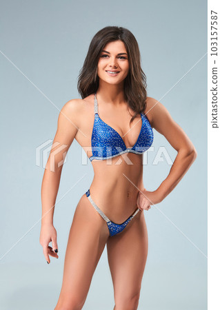 Sexy brunette bodybuilder woman in blue bikini. 103157587