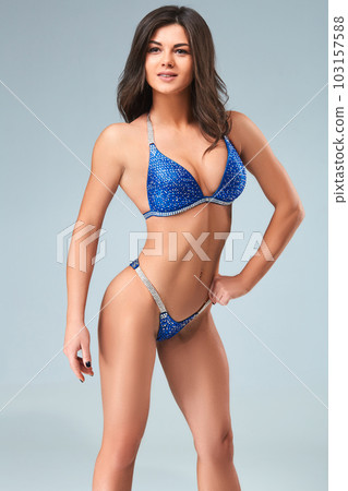 Sexy brunette bodybuilder woman in blue bikini. Sexy brunette bodybuilder woman in blue bikini. 103157588