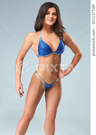 Sexy brunette bodybuilder woman in blue bikini. Sexy brunette bodybuilder woman in blue bikini. 103157589