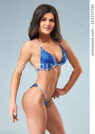 Sexy brunette bodybuilder woman in blue bikini. Sexy brunette bodybuilder woman in blue bikini. 103157590