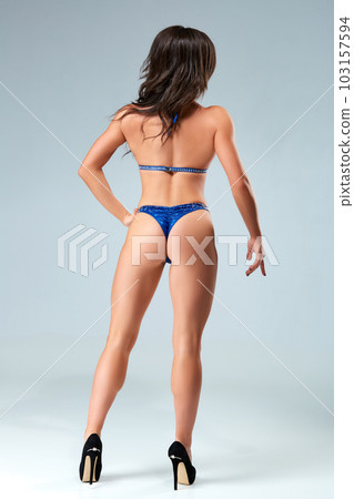 Sexy brunette bodybuilder woman in blue bikini. Sexy brunette bodybuilder woman in blue bikini. 103157594