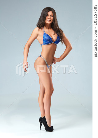 Sexy brunette bodybuilder woman in blue bikini. Sexy brunette bodybuilder woman in blue bikini. 103157595
