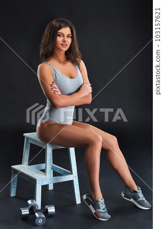Portrait of a beautiful girl athlete with dumbbell in studio Portrait of a beautiful girl athlete with dumbbell in studio 103157621