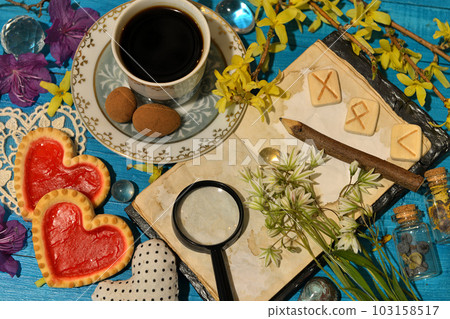 Runes, old diary book with open pages and cup of coffee on ritual altar table. Occult, esoteric and divination still life. Mystic background with vintage objects Runes, old diary book with open pages and cup of coffee on ritual altar table. Occult, esoteric and divination still life. Mystic background with vintage objects 103158517