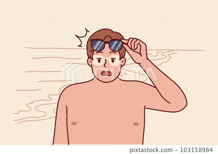 Tanned man takes off sunglasses and screams after getting sunburn relaxing on beach 103158984