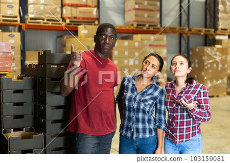 Owner of the factory gives instructions to the worker in the warehouse 103159081