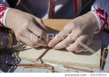 The hands of an artisan make a craft from straw. Hand made product The hands of an artisan make a craft from straw. Hand made product 103159519