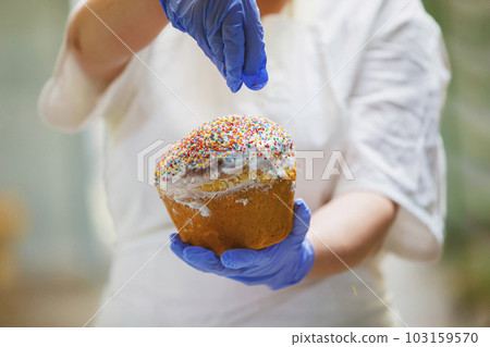 Hands decorate Easter bun. Professional baking Easter cakes. Hands decorate Easter bun. Professional baking Easter cakes. 103159570