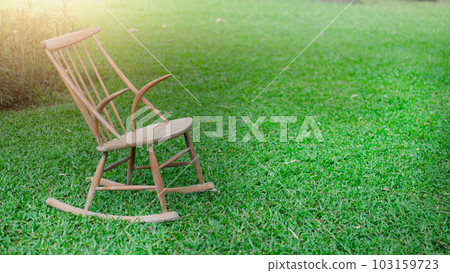 Wooden chair on green grass at garden Wooden chair on green grass at garden 103159723
